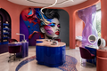 Colorful woman wallpaper mural displayed in a modern nail salon with manicure tables, blue cabinetry and professional beauty stations.