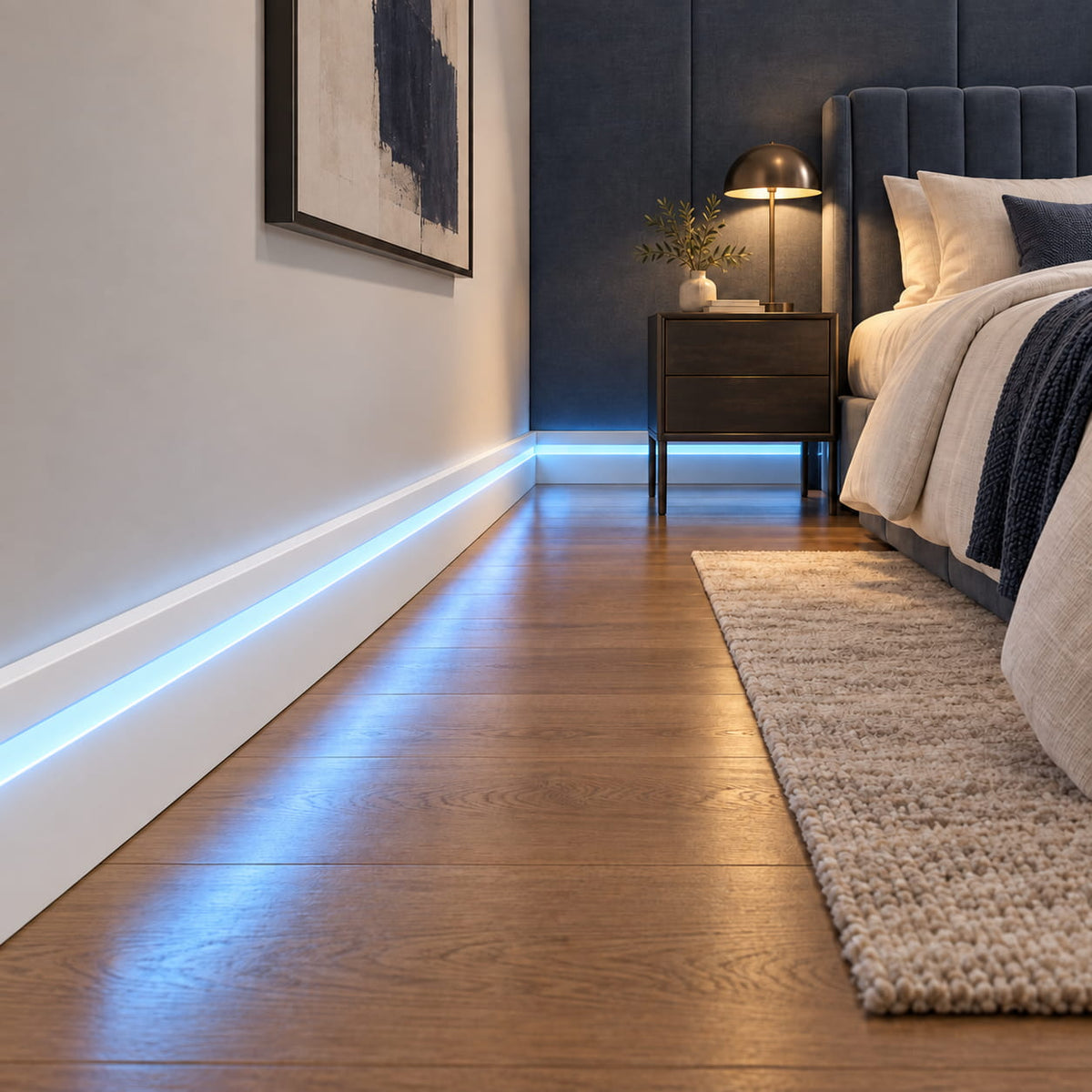 Hidden LED channel baseboard trim with seamless blue lighting along the wall and wood floor